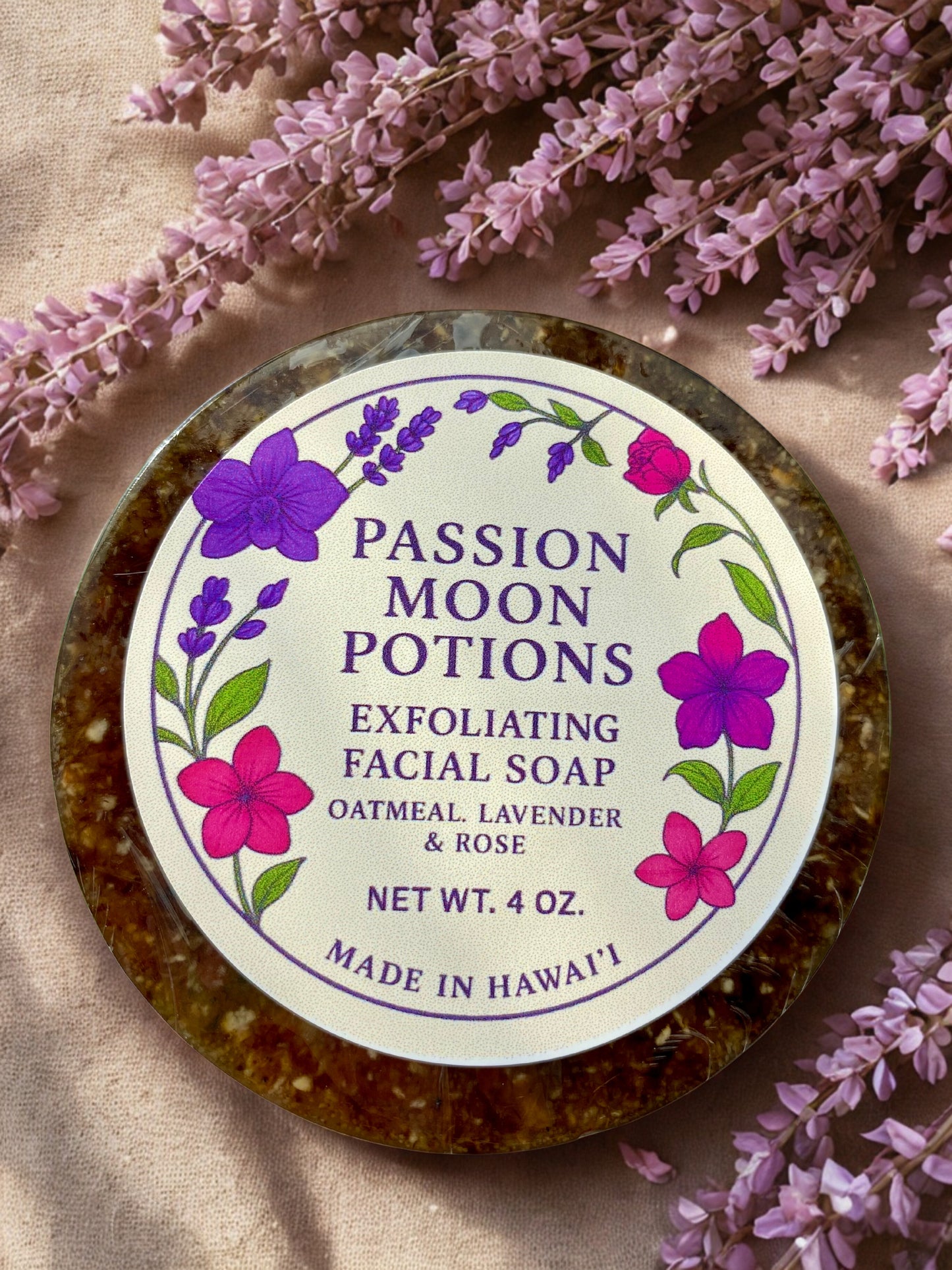 Exfoliating facial soap with 'Passion Moon Potions' label surrounded by lavender flowers.