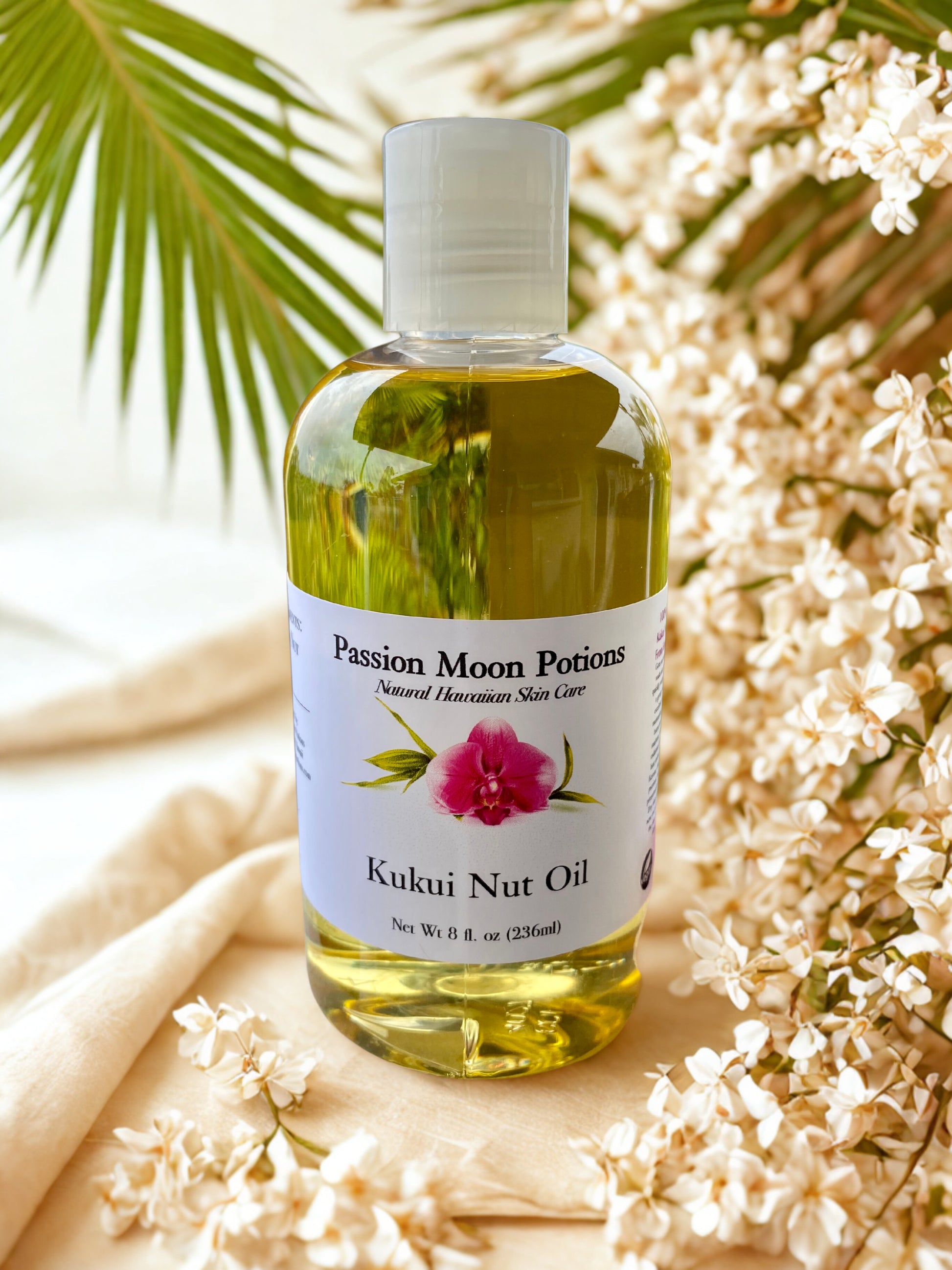 Bottle of Passion Moon Potions Kukui Nut Oil with a floral background