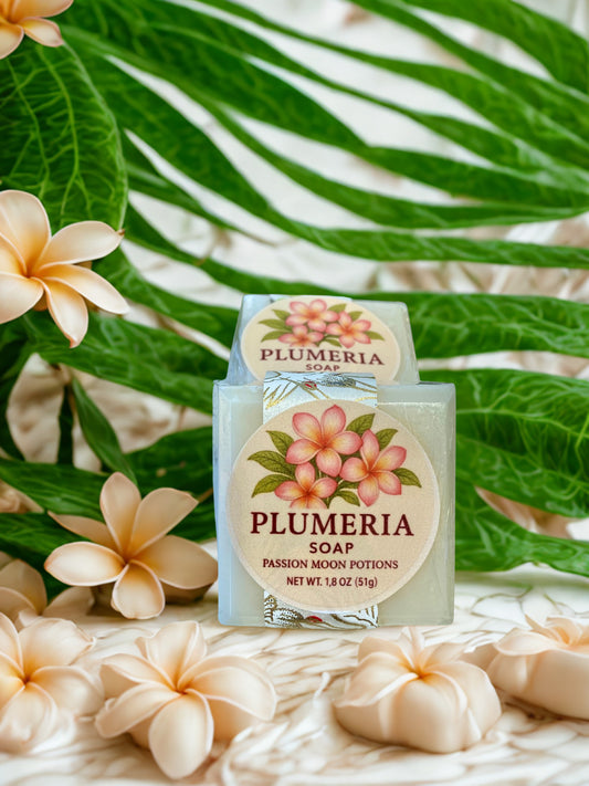Plumeria soap with floral packaging against a green leafy background