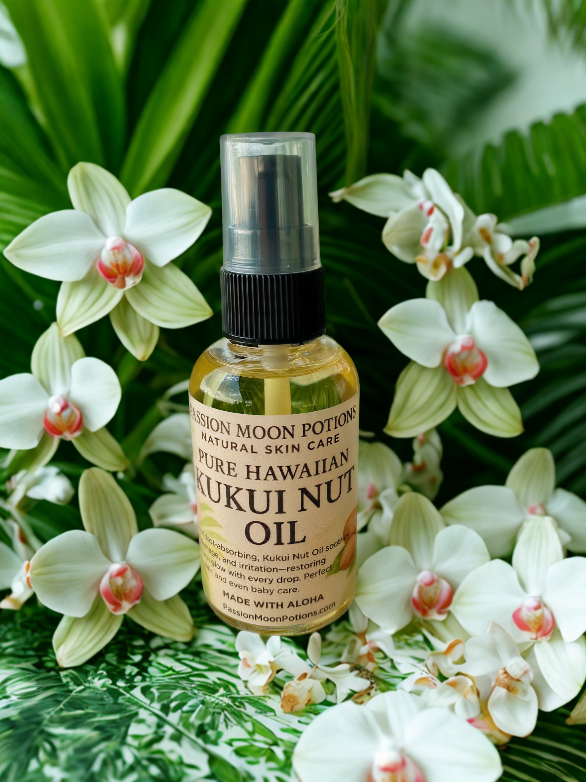 Bottle of Pure Hawaiian Kukui Nut Oil surrounded by white flowers on a green leafy background